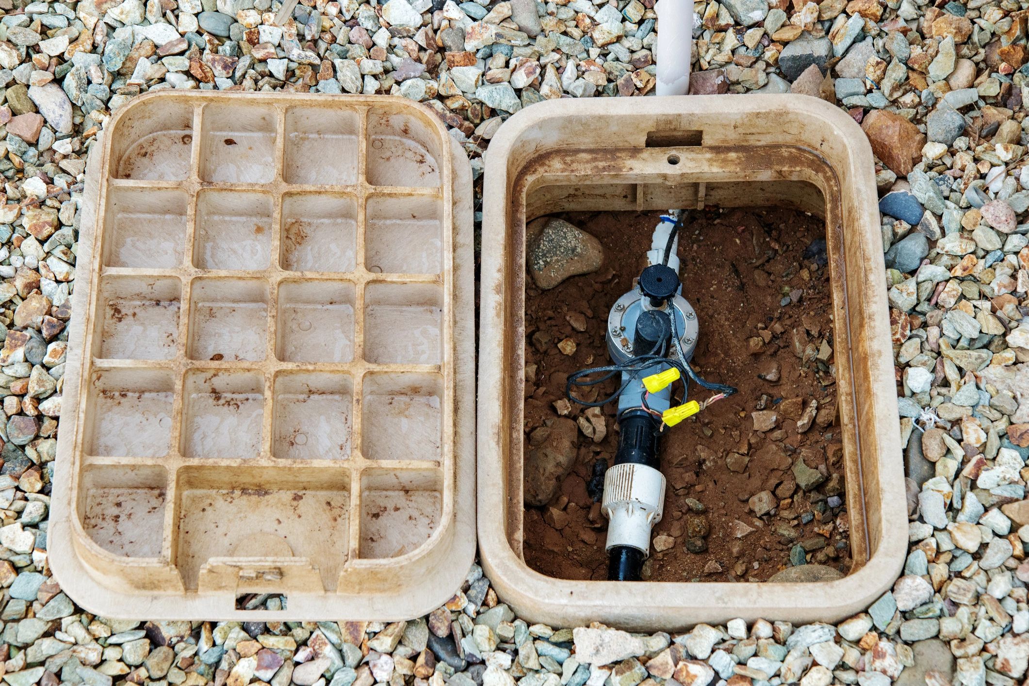 Open residential sprinkler valve box with irrigation valves and wiring